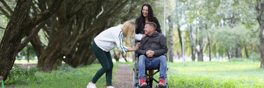 Happy young man communicates with girlfriends in park - Powered by Adobe