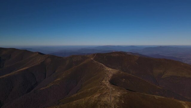 Drone flies over the mount Gemba and mountain range in early autumn, Ukrainian Carpathians landscape at sunny day