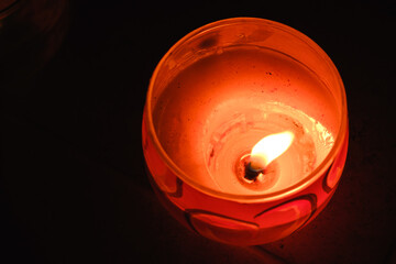 Burning candle flame on a black background. Top view. Glass candlestick. Slow motion. Romantic...