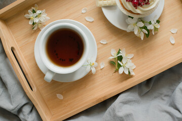 Pastries and a cup with a drink on a wooden tray