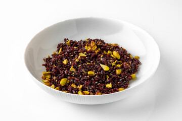 Brown rice with pistachios and seeds. Balanced, nutritious, tasty and nutritious food. Ready-made menu for a restaurant or for delivery. Dish in a white plate isolated on a white background.