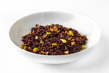 Brown rice with pistachios and seeds. Balanced, nutritious, tasty and nutritious food. Ready-made menu for a restaurant or for delivery. Dish in a white plate isolated on a white background.