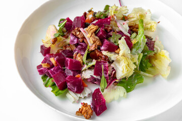 Vegetable salad with red cabbage and sun-dried tomatoes. Balanced, nutritious, tasty and nutritious food. Ready-made menu for a restaurant or for delivery. Dish in a white plate isolated on a white