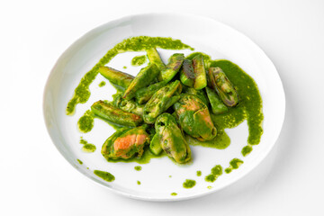 Cooked mussels in green sauce. Balanced, nutritious, tasty and nutritious food. Ready-made menu for a restaurant or for delivery. Dish in a white plate isolated on a white background.
