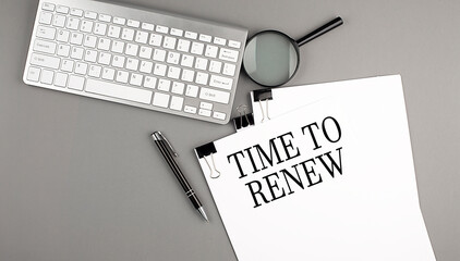 TIME TO RENEW text on paper with keyboard, magnifier and pen. Business concept