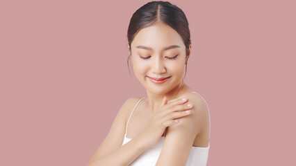 Close up perfect beauty face of young beautiful Asian woman applying moisturizer cream on her shoulder and arm gently.