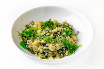 Wheat porridge or bulgur with seaweed and chukka. Balanced, nutritious, tasty and nutritious food. Ready-made menu for a restaurant or for delivery. Dish in a white plate isolated on a white