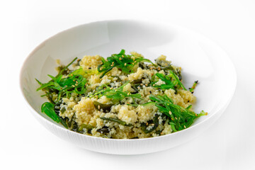 Wheat porridge or bulgur with seaweed and chukka. Balanced, nutritious, tasty and nutritious food. Ready-made menu for a restaurant or for delivery. Dish in a white plate isolated on a white