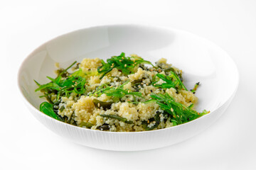 Wheat porridge or bulgur with seaweed and chukka. Balanced, nutritious, tasty and nutritious food. Ready-made menu for a restaurant or for delivery. Dish in a white plate isolated on a white