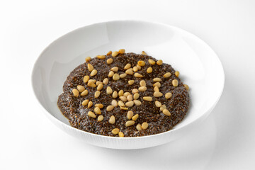 Chia with pine nuts. Balanced, nutritious, tasty and nutritious food. Ready-made menu for a restaurant or for delivery. Dish in a white plate isolated on a white background.