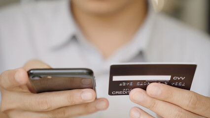 Closeup Businessman filling online shopping on smarphone with holding credit card in hand using instant easy mobile payments making purchase in online store.