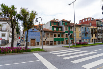 Naklejka premium Porto street, with the houses and their tiled facades, with a traffic light, on a cloudy day.
