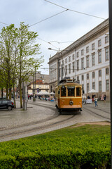 Fototapeta premium Old yellow tram of the city of Porto, going through the streets.