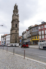 Tower of the Clérigos Church in Porto, seen from across the street, with parked tourist cars.