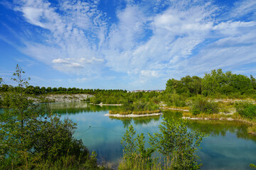Obraz na płótnie Canvas View of the Dyckerhoff lake in Beckum. Quarry west. Blue Lagoon. Landscape with a turquoise blue lake and the surrounding nature. 