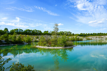Fototapeta na wymiar View of the Dyckerhoff lake in Beckum. Quarry west. Blue Lagoon. Landscape with a turquoise blue lake and the surrounding nature. 