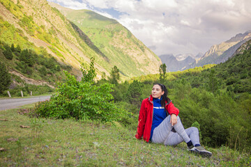 Fototapeta na wymiar happy romantic girl sitting in the mountains enjoying fresh mountain air and birds singing