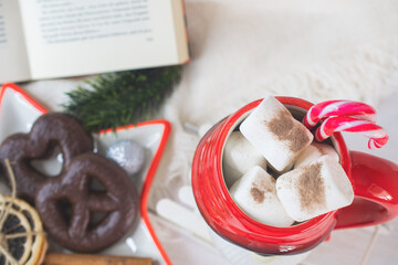 Fototapeta na wymiar New Year's Eve background, Santa Claus mug with marshmallows, Christmas cookies, open book