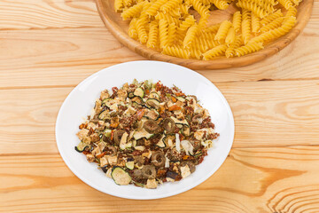 Mixture of spices and dried vegetables against the spiral pasta