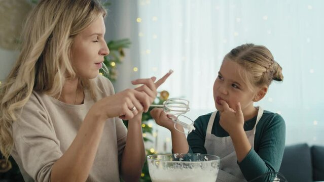 Caucasian mother and daughter preparing baking using electric mixer and later tasting. Shot with RED helium camera in 8K.   