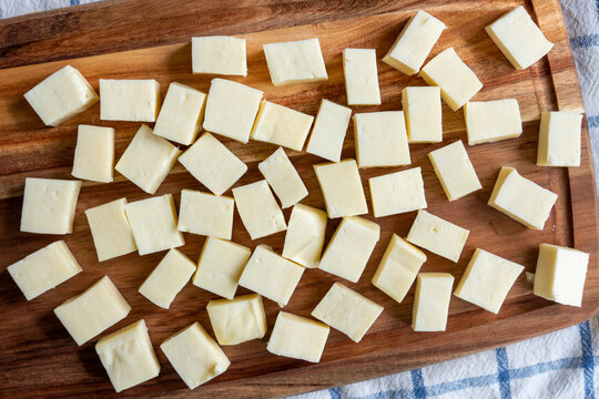 Paneer Or Indian Cottage Cheese Cut Into Cubes On A Wooden Chopping Board. Top View.