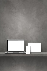Laptop, mobile phone and digital tablet pc on grey wall shelf. Vertical background