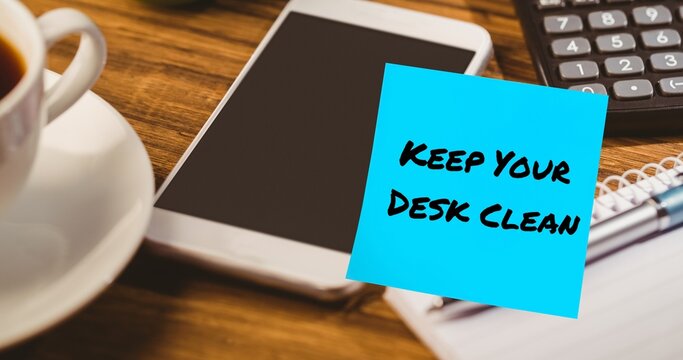 Composite of keep your desk clean text on blue sticky note with cellphone, calculator and coffee