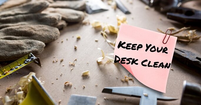 Composite Of Keep Your Desk Clean Text On Sticky Note With Carpentry Tools And Gloves On Messy Table