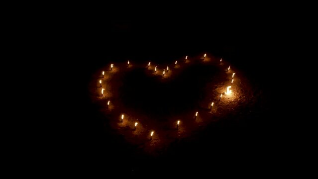 Fire heart of burning torches flickering in darkness, aerial view.
