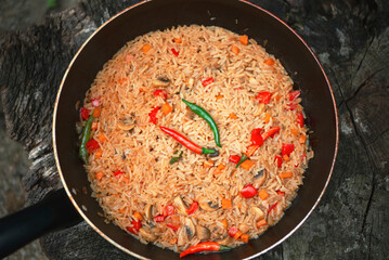 spicy fried rice with mushrooms and vegetables in a frying pan