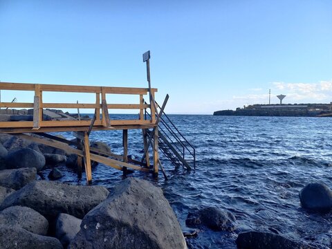 Passerella in legno e scaletta in ferro per agevolare la discesa a mare