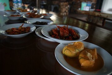 Minangkabau traditional food is being served on the dining table