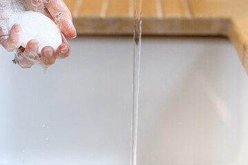 person washing hands in bathroom