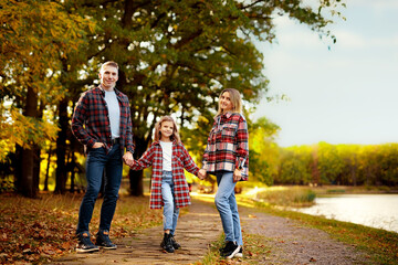 Fototapeta premium Beautiful young family on a walk in autumn forest