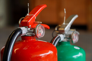 red fire extinguisher and green tanks for use in industrial emergencies,fire prevention concept