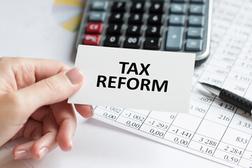 Closeup on businessman holding a card with text TAX REFORM, business concept image with soft focus background and vintage tone