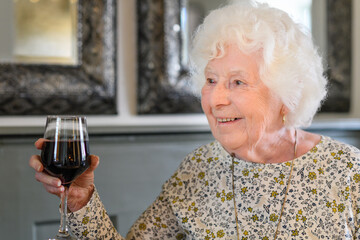 portrait of a senior woman drinking wine