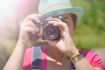 Mujer turista tomando fotos en verano con cámara antuigua