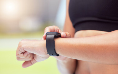 Obraz na płótnie Canvas Smartwatch on hands of runner to track woman running time, health stats and train for competition race. Smart watches help competitive performance, motivate and inspire athlete to improve record time