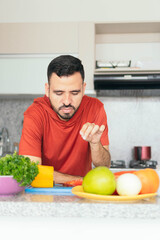 Fototapeta premium Latin man cooking a healthy salad of fruits and vegetables.