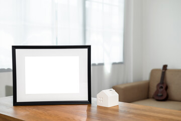 Style picture frame still life put on the wooden table in living room. Blank space empty picture frame with mockup. Natural light Template background interior design and decoration