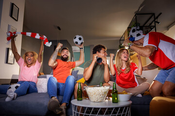 People cheering while watching football match on TV