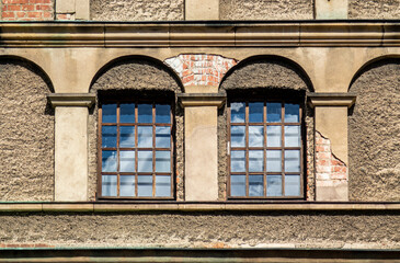 Two clean windows on an old building reflecting the sky