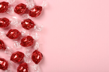 Candies on pink background, flat lay, top view with copy space	