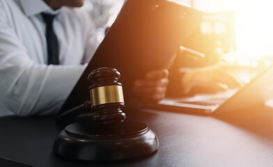 Male lawyer working with contract papers and wooden gavel on tabel in courtroom. justice and law...