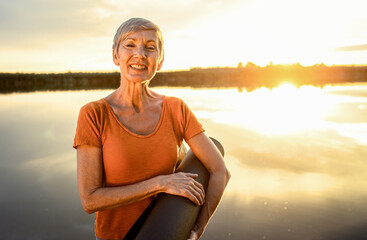 Portrait of senior woman with yoga mats.