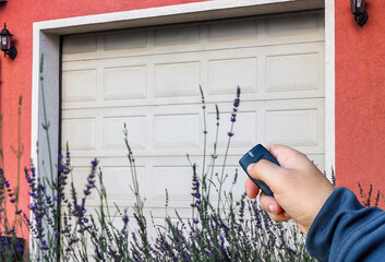 Garage door PVC. Hand use remote controller for closing and opening garage door
