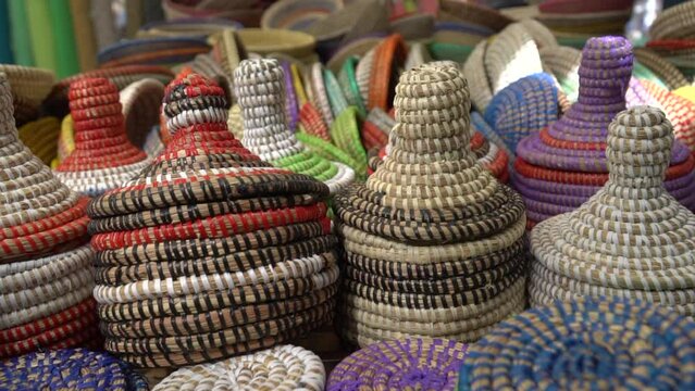 Decorative accessories for storage or carrying. Handmade colorful straw containers and pots selling on the market as a decorative baskets. 