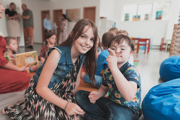 A girl and a boy with Down's syndrome in each other's arms spend time together in a preschool institution