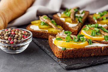 canapes with sprats on a black stone tray